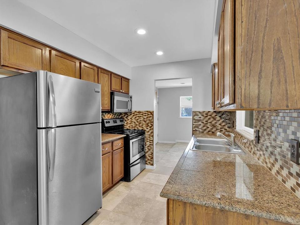 Kitchen highlights are Wood Cabinets, Stainless Steel Appliances and granite counters with a stylish sea glass backsplash.