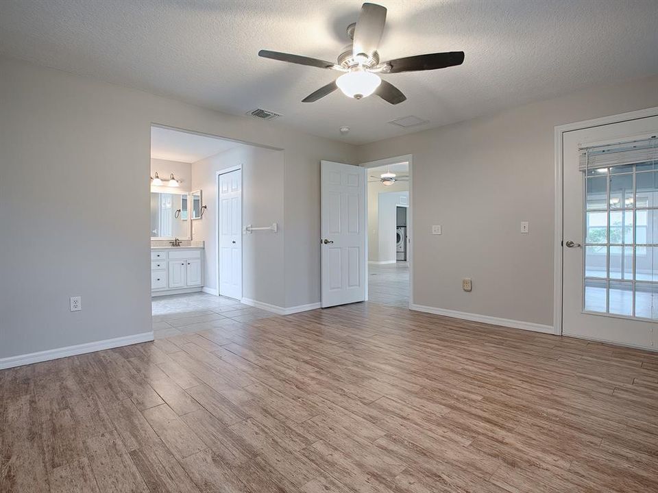 SPACIOUS MASTER BEDROOM HAS BEAUTIFUL FLOORING THROUGHOUT AND FRENCH DOORS THAT LEAD TO THE LANAI