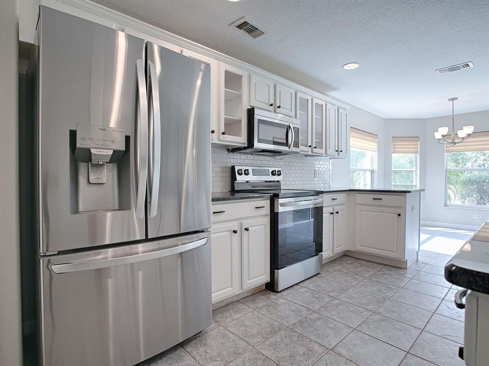 STAINLESS STEEL APPLIANCES AND A GORGEOUS SUBWAY TILED BACKSPLASH