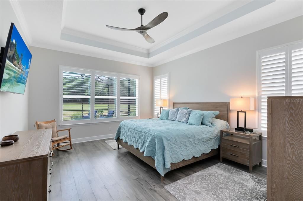 The master bedroom offers stunning pool and golf course views, along with dual walk-in closets.