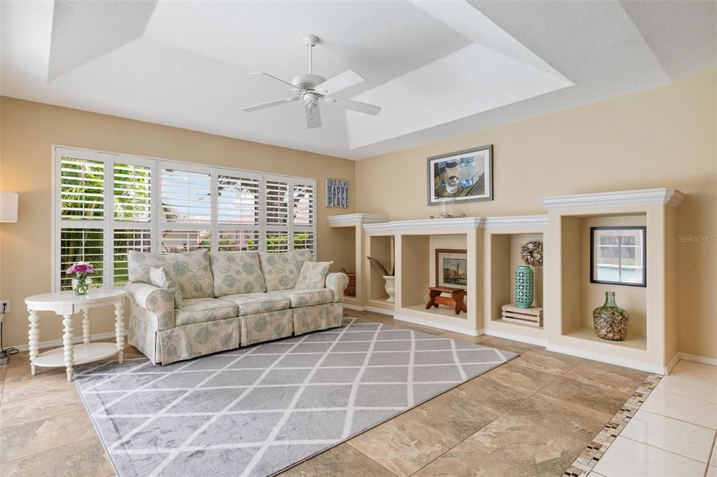 Family room with Plantation shutters, tray ceilings, built-ins