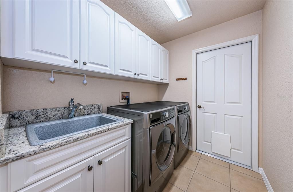Laundry room with refaced cabinets and granite counters. 2017 Kenmore Washer/dryer.
