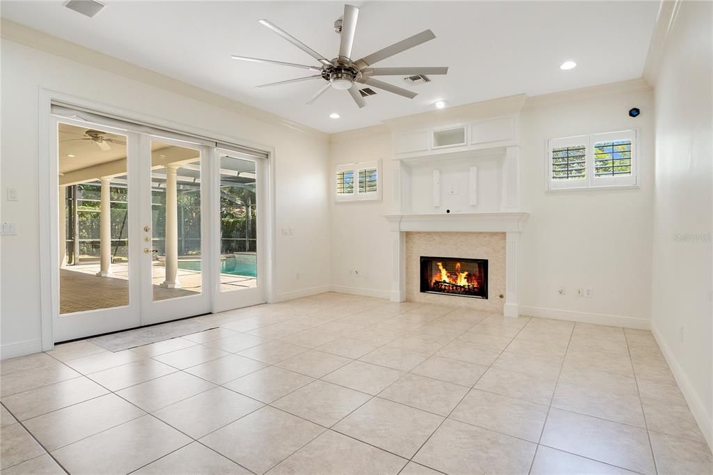 Spacious family room with gas fireplace and French doors that lead to the private pool and covered lanai.