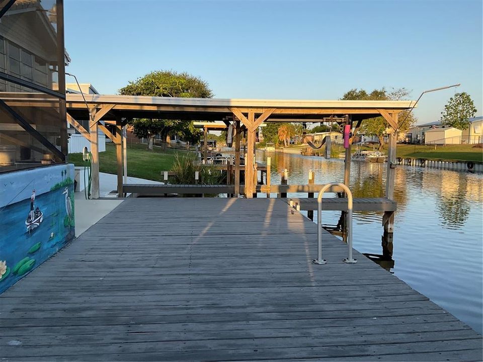 Wooden dock and covered boat slip with lift
