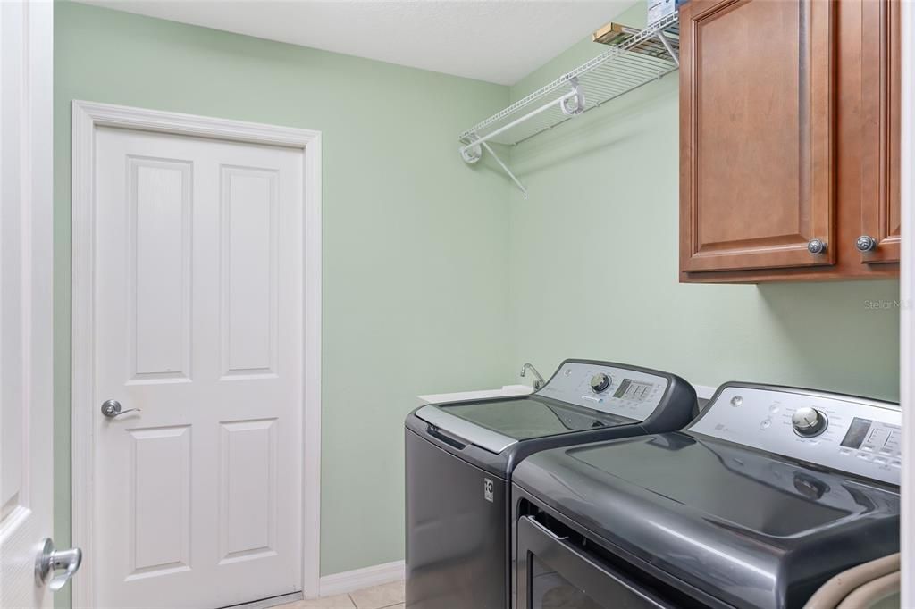 INSIDE LAUNDY ROOM WITH NEWER WASHER, DRYER AND DEEP SINK