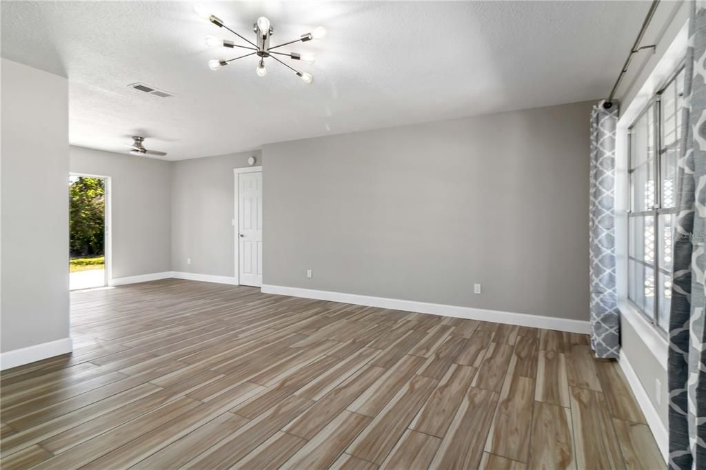 Living room. New tile floor throughout home, new larger baseboards, lighting