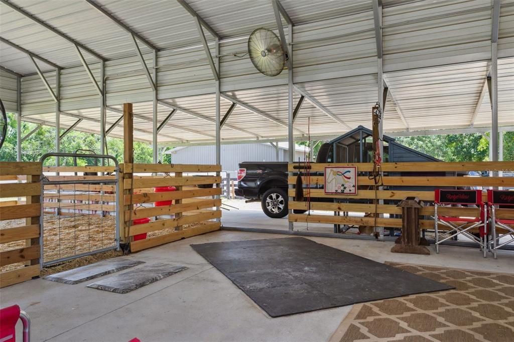 Pole barn attached to double RV garage. Currently used as animal pens, but pull up the rubber pads and wood shavings to reveal concrete pad for auto or RV storage