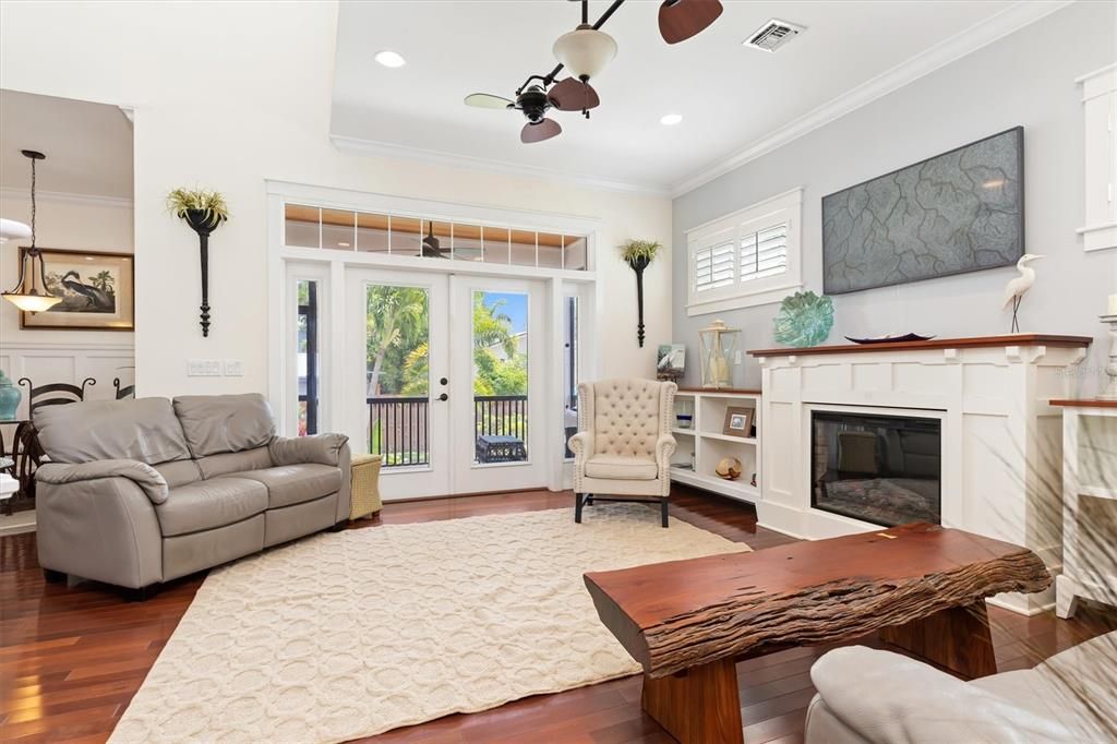 Your cozy family room that conveniently opens to the rear screened porch overlooking the pool and picturesque garden-like setting