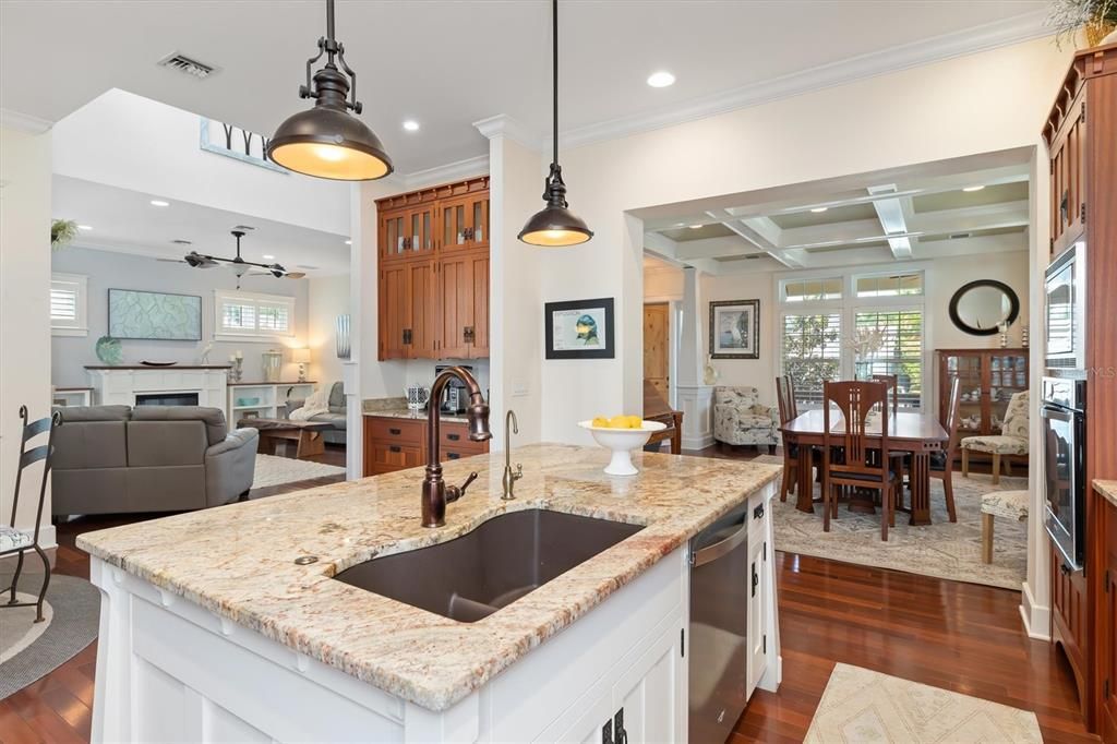 The chef’s kitchen is adorned with custom cabinetry featuring Sapele wood, a huge center prep island, granite counters, cooktop with pot-filler, kitchen R/O, stainless steel appliances, dry bar and breakfast nook