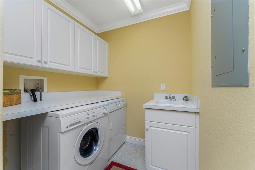 The laundry room features a full size washer and dryer with full length counter for folding clothes.