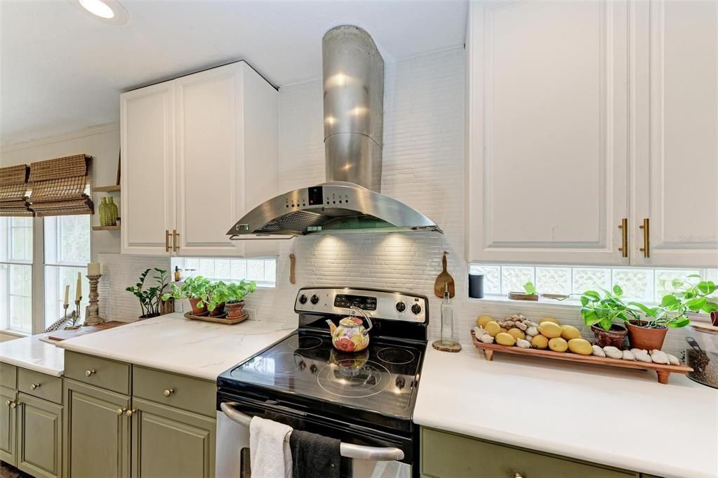 Kitchen with stainless steel vent hood.