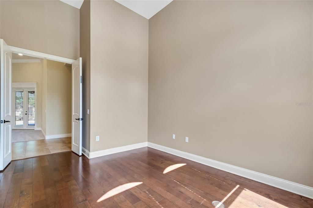 The office in flooded with natural light , has wood flooring and high ceilings.