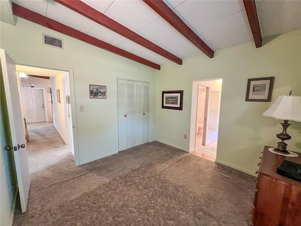 From the corner of the Primary Bedroom. The hallway to the other bedrooms and the front of the house is seen on the left side of the photo. The opening to the right of center in this photo leads into the Walk-In Closet. A sliver of Bathroom 2 can also be seen through that opening in this photo.