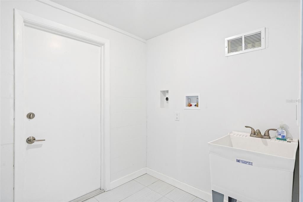 Laundry room with door to backyard off of the garage