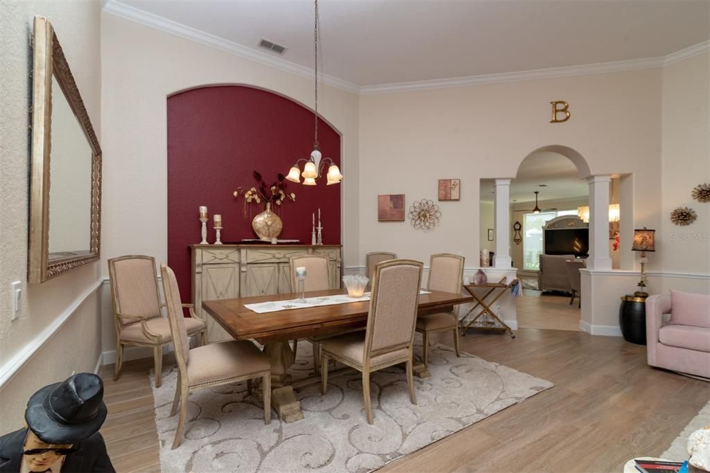 Large formal dining in open concept area featuring Living room and crown molding