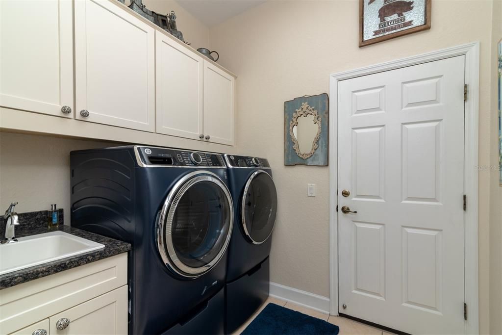 Laundry room with sink, washer and dryer which convey with home and extra storage cabinets