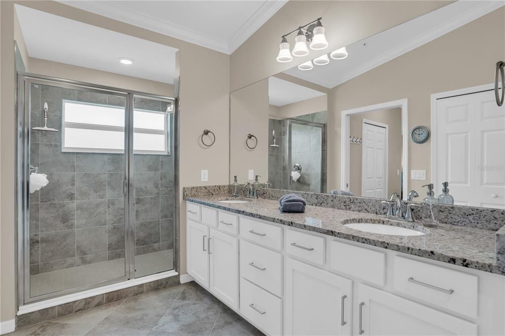 Owners bath features dual vanity, granite counters, natural light & porcelain tile floors.