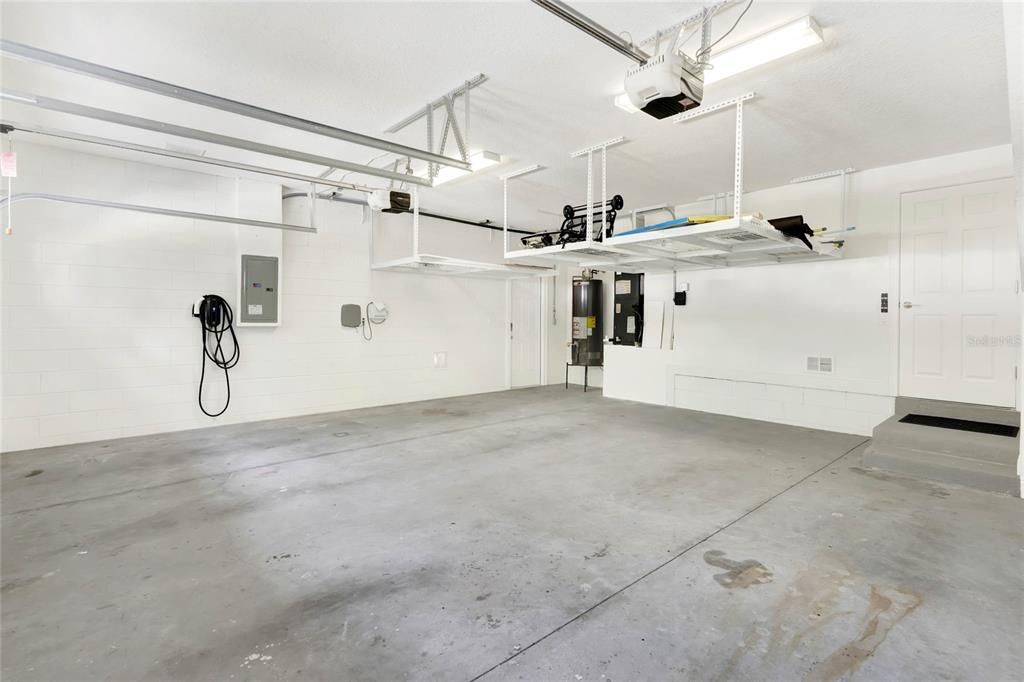 Garage with overhead shelving and electric vehicle plug
