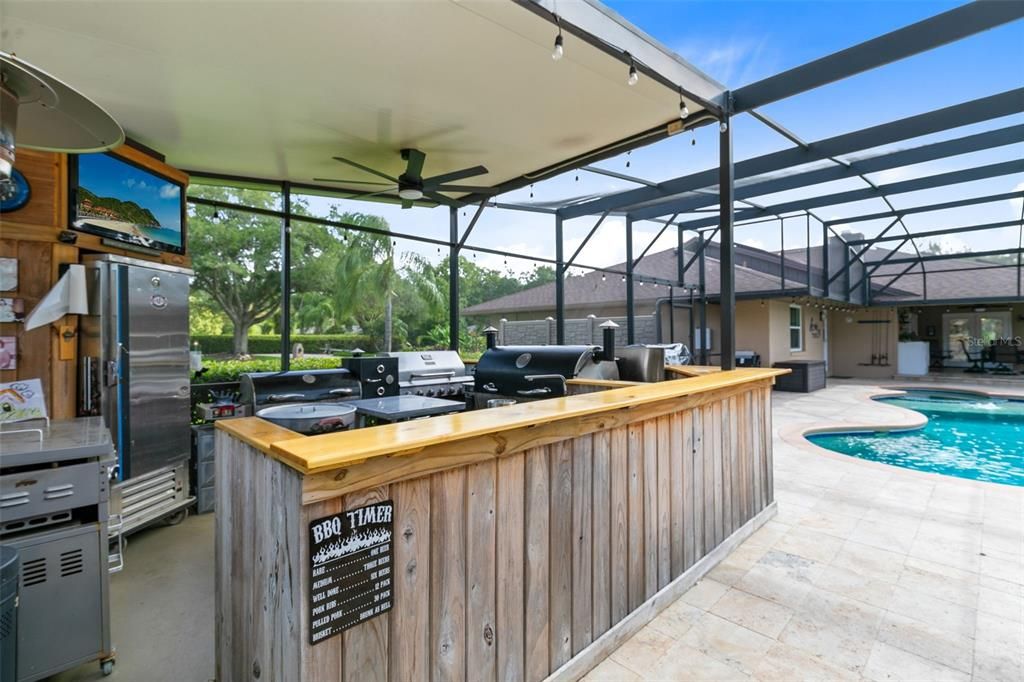 Outdoor Kitchen with kitchen with sink, mini fridge, 2 burner stovetop with griddle, 36 inch Blackstone griddle and a bar-b-que grill
