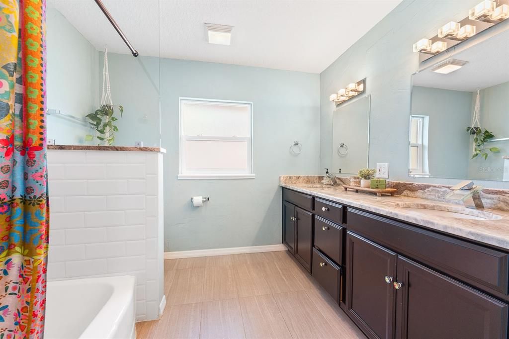 Guest Bathroom with large double sink vanity and tub/shower combo