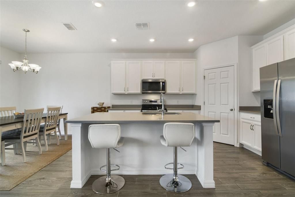The kitchen is designed with the home chef in mind offering STAINLESS STEEL APPLIANCES, solid surface countertops, BREAKFAST BAR on the large ISLAND and ample storage space.