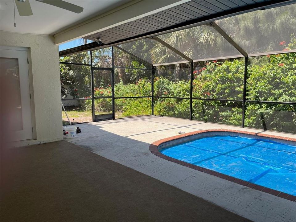 Screen enclosed solar heated pool has child safety fence stored in the garage