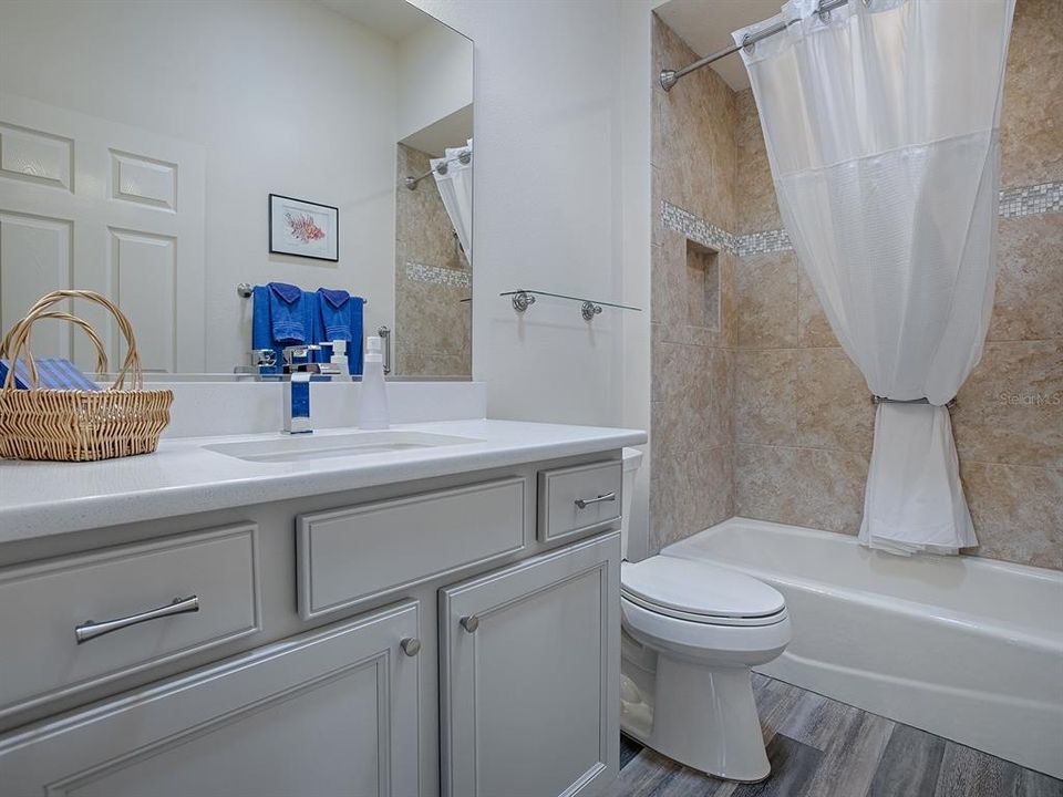 GUEST BATH WITH QUARTZ COUNTERTOPS AND LOVELY TILE SHOWER/TUB.