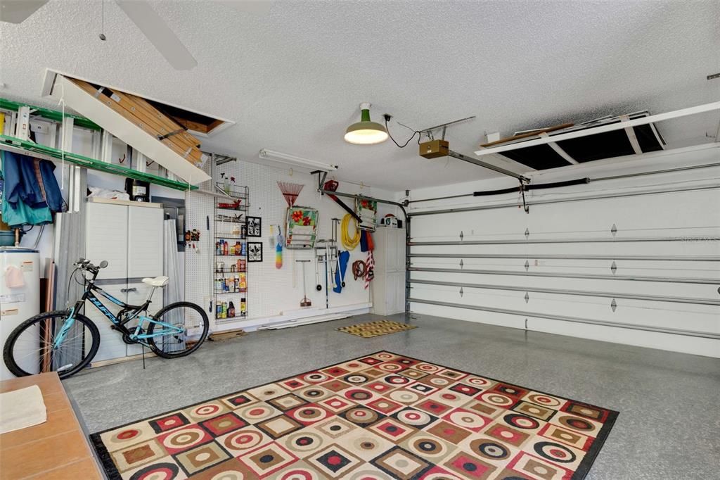 @ car attached garage showing full wall pegboard and attic entrance