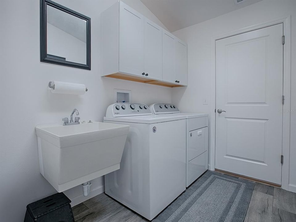 INSIDE LAUNDRY ROOM WITH EXTRA CABINETS FOR STORAGE. WASHER AND DRYER OF COURSE CONVEY WITH THE HOME. THIS DOOR LEADS TO THE SPACIOUS 2 CAR GARAGE.