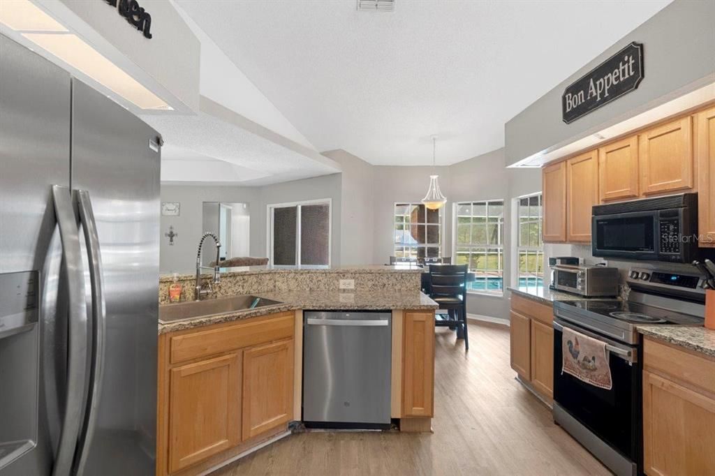 Spacious kitchen featuring granite countertops, stainless steel appliances, and a pantry.