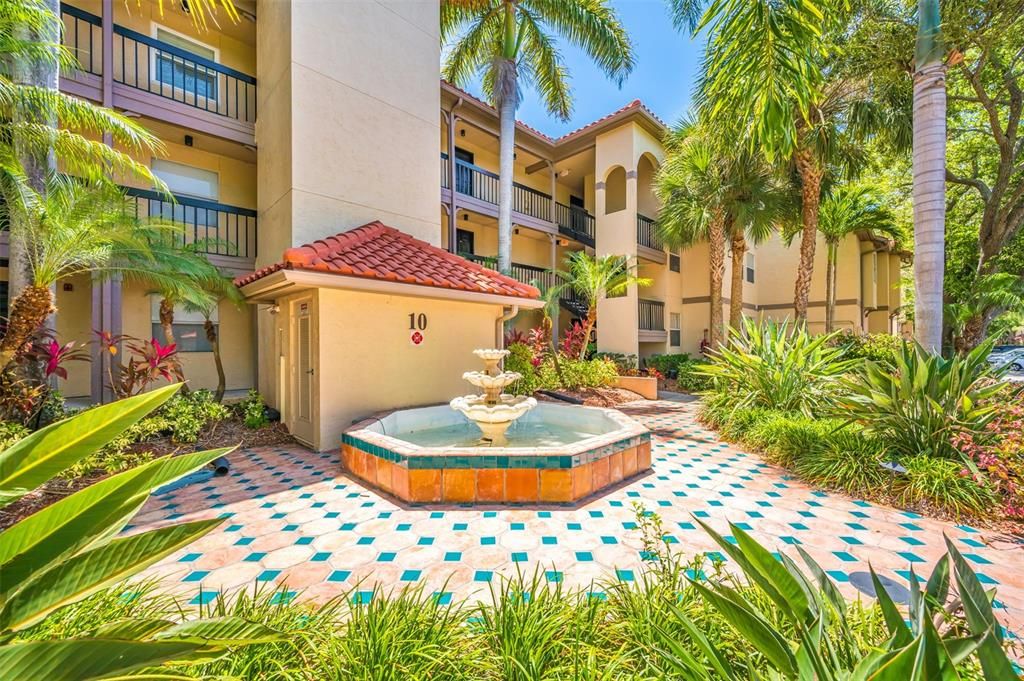 Front View of Building 10, Condo Unit #1026. Lush, Tropical Florida Landscaping! A soothing Waterfall. Elevators and Stairs for your convenience.