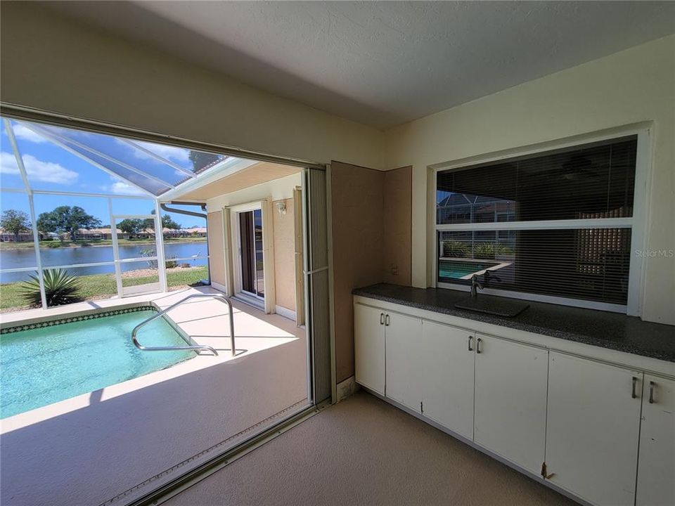 Large covered lanai with pass-through from kitchen & overlooking pool & lake