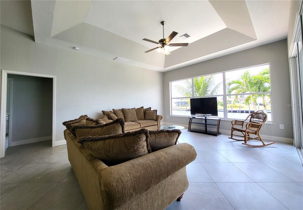 Tray ceiling, a wall of large windows facing the canal, and a triple sliding door flood the Family room with light.