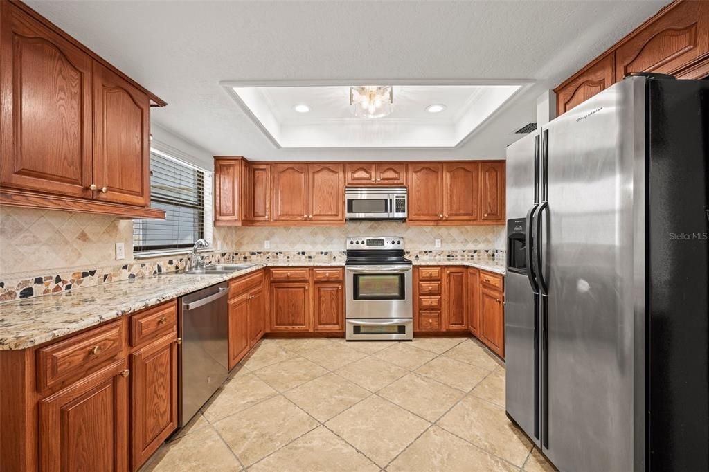 Spacious kitchen featuring granite countertops, stainless steel appliances and a large window for great natural light
