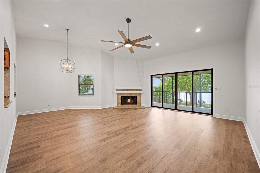 Spacious living and dining room with a wood burning fireplace, all new flooring, new lighting and high ceilings