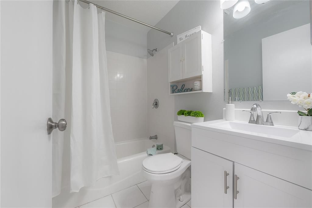 Bathroom.  New vanity, mirror, and light.  Newer toilet.