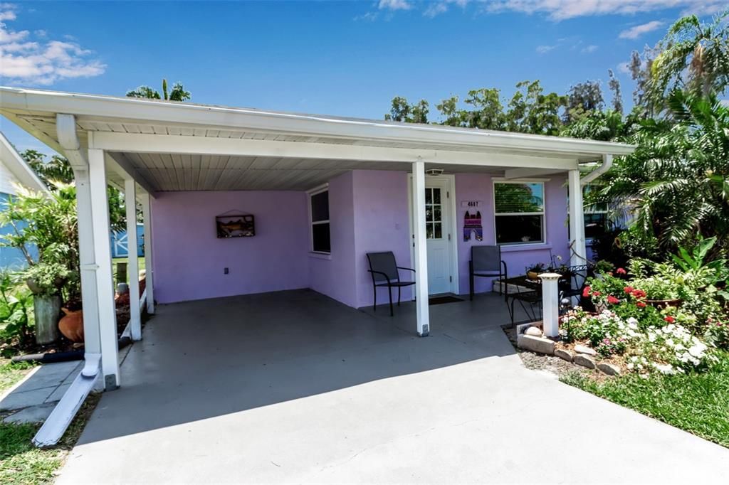 Your carport and front door flanked by colorful landscaping.