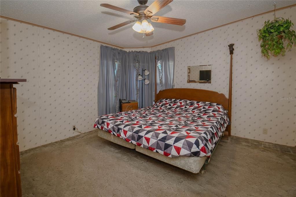 Primary bedroom with ceiling fan.