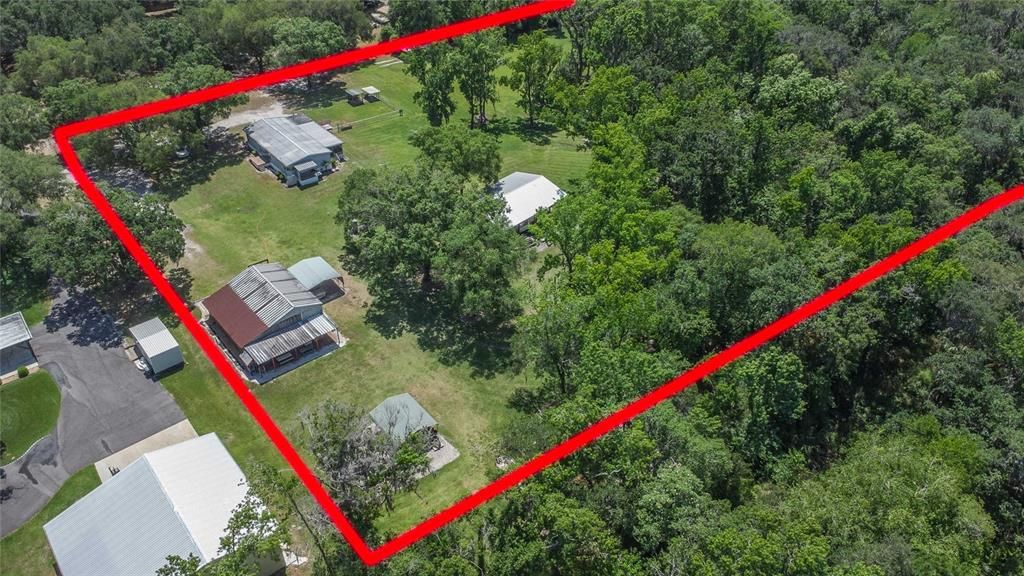 Ariel view of the home, barn/workshop, 1 of the carports, and the Pole barn.