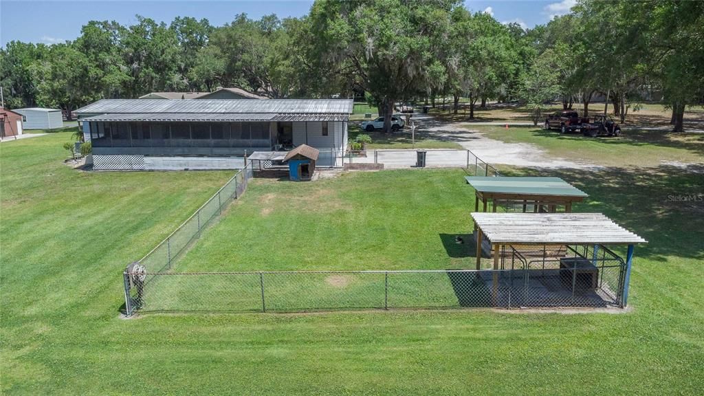 Rear view of the fenced Dog pen and the screened patio.