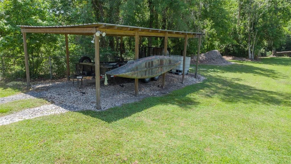 Covered storage carport/boat shed in the side yard.