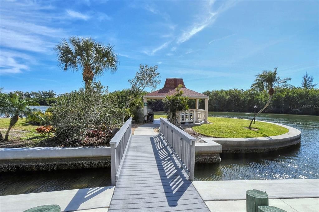 Bridge to a separate island housing the gazebo with BBQ grills and seating.