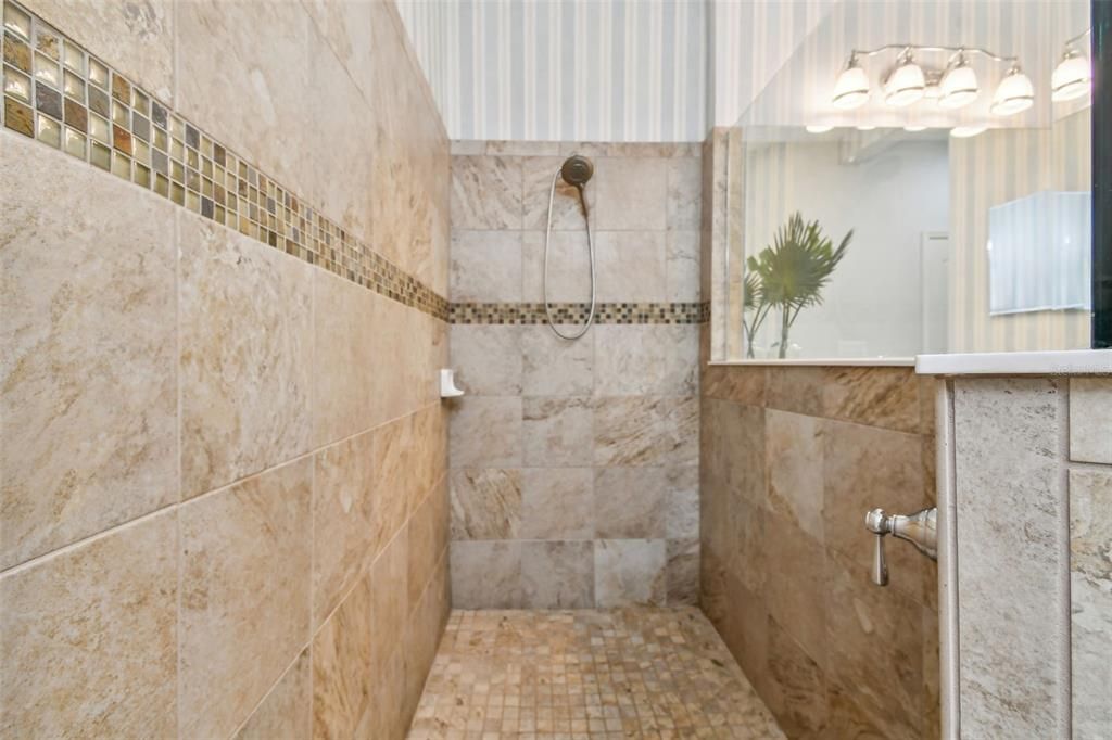 Ceramic tile walls and glass shower enclosure. Complimentary decorator 17" tile flooring.