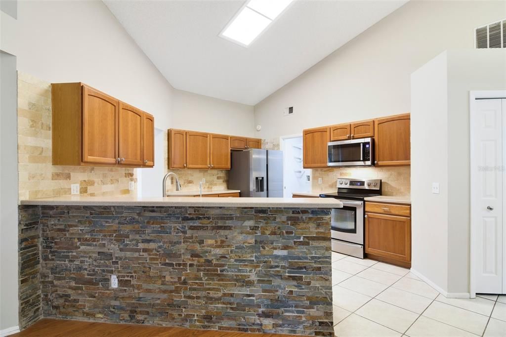 The family chef will appreciate the large open kitchen offering solid wood cabinets and solid surface counters, stainless steel appliances, decorative backsplash, pantry for ample storage and a casual dining space with sliding glass door access to the SCREENED LANAI.