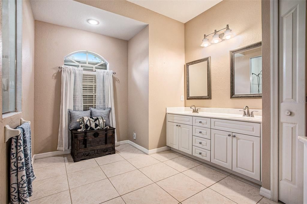 The gorgeous bathroom has a walk-in shower, dual sinks, his & hers walk-in closets, and a linen closet.