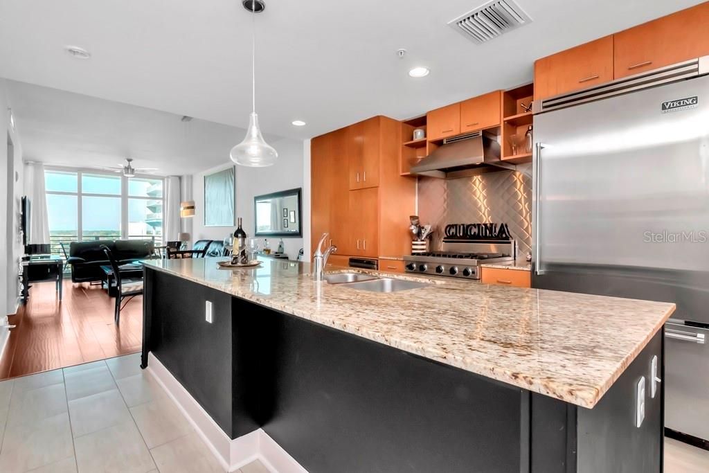 Chef's kitchen includes high-end stainless-steel Viking appliances - gas range, oven, modern cabinetry, granite countertops and oversized island.