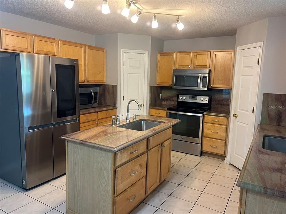 Kitchen with granite counter tops, stainless steal appliances and double panty