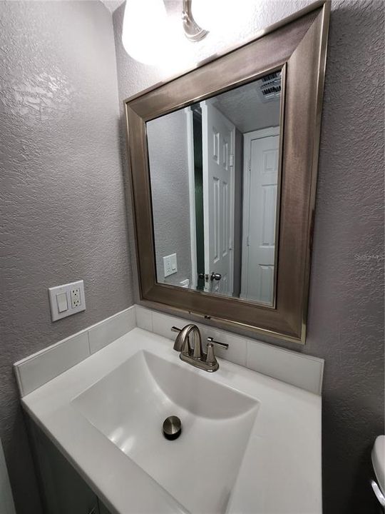 Main bathroom with new vanity and mirror with coordinating lights