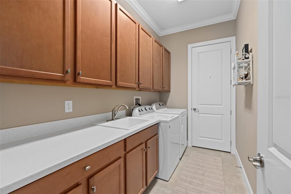 Laundry Room offering Upper and Lower Cabinetry with a Sink