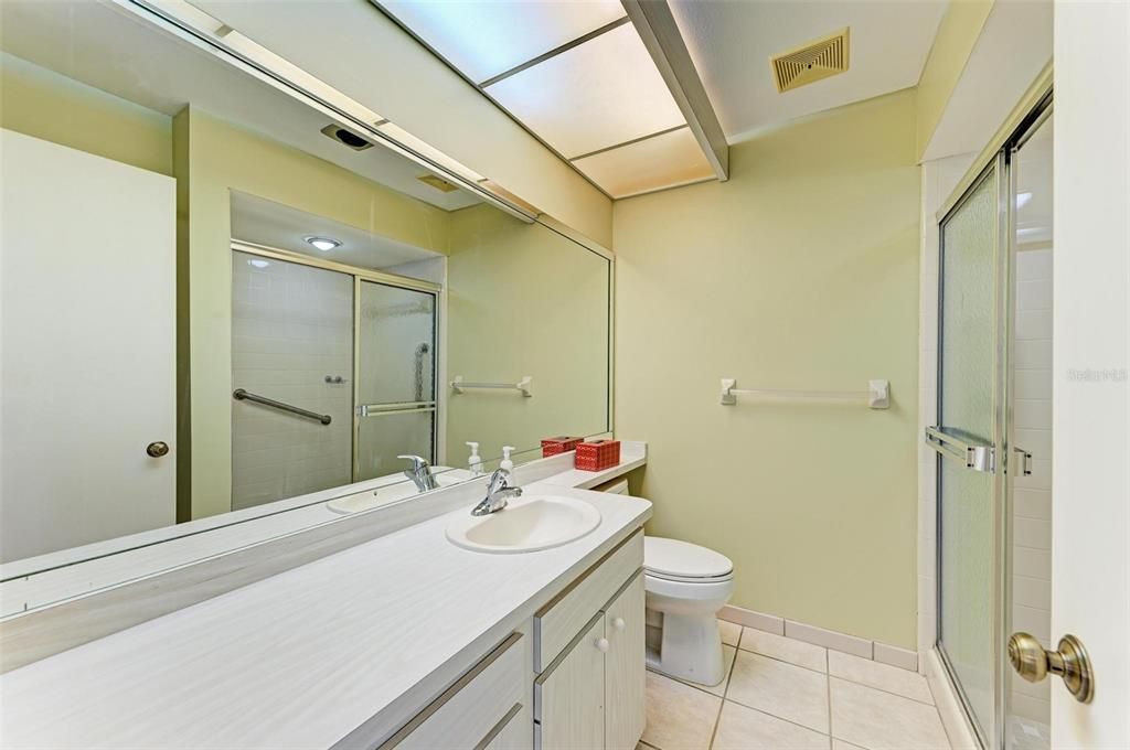 Primary en suite bathroom with walk-in shower and linen closet behind entry door.